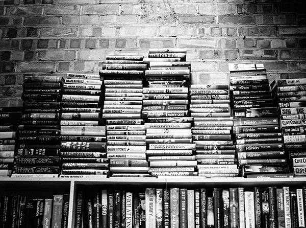 A black & white photo of book stacked