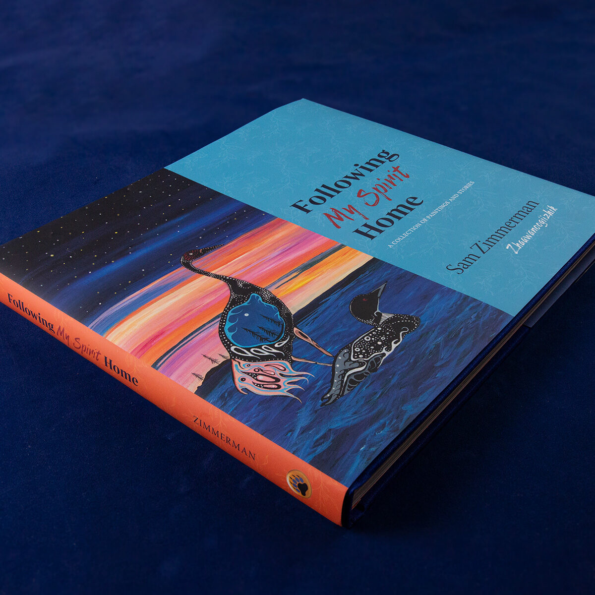 Front cover of book showing artist depiction of a crane and a loon, and orange spine on blue background